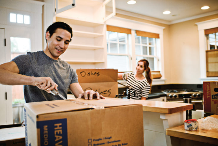 A man cutting open a box with a Leatherman.